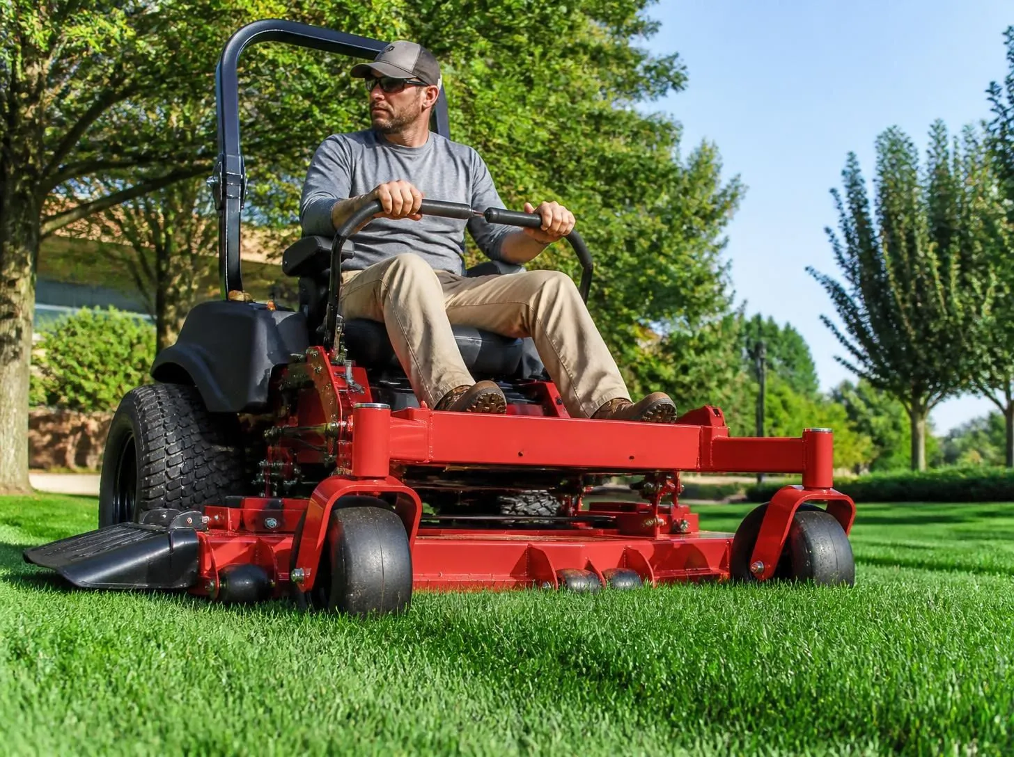 Commercial zero-turn mower cutting grass in a park