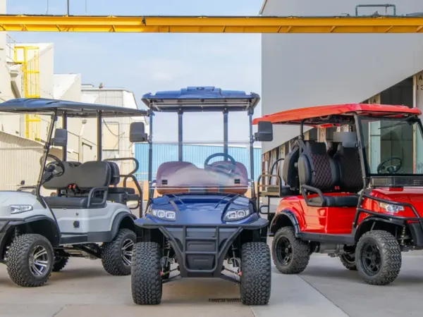 Lineup of lifted golf carts outside a service warehouse