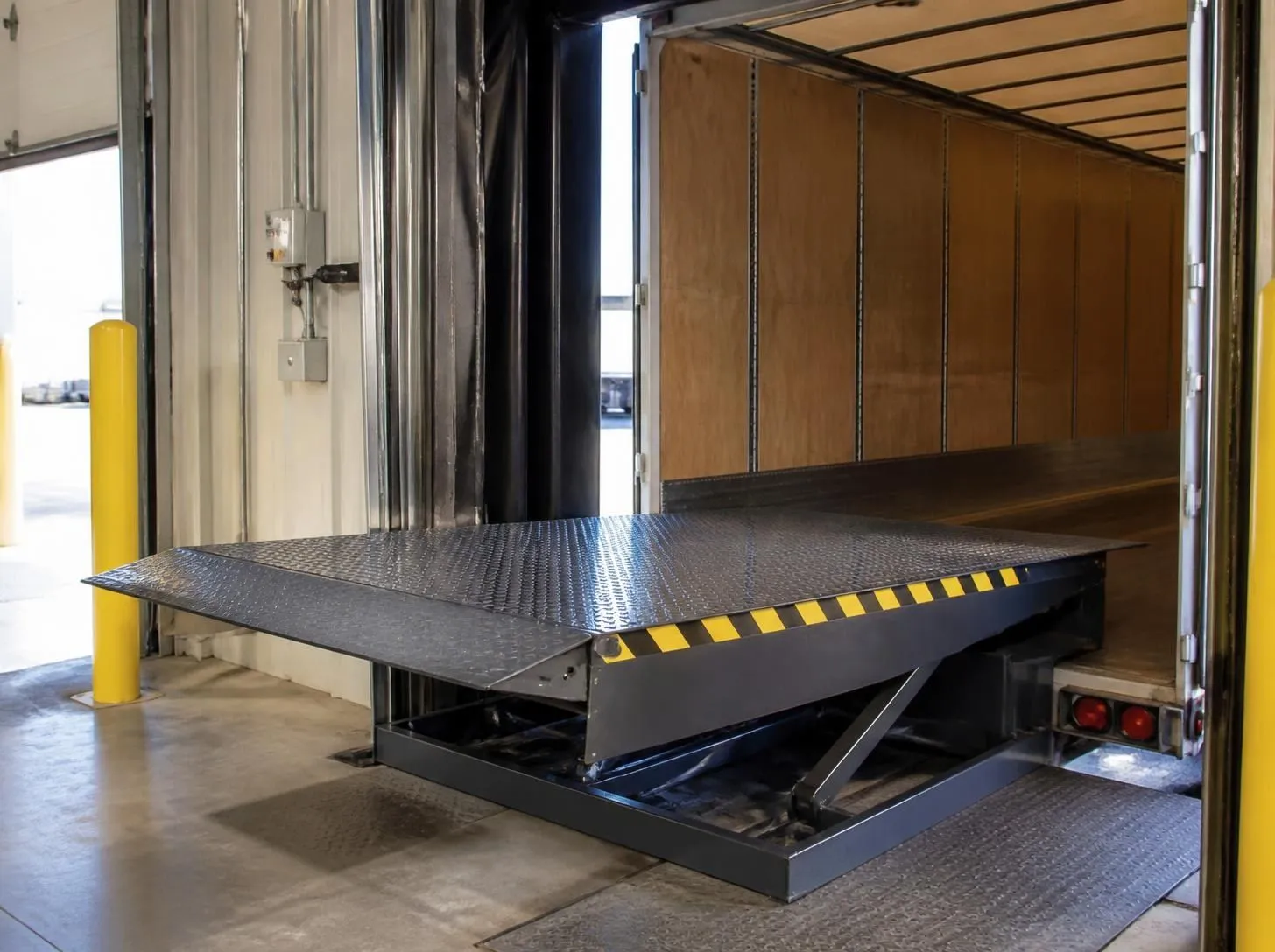 Hydraulic dock leveler bridging the gap into a semi-truck trailer